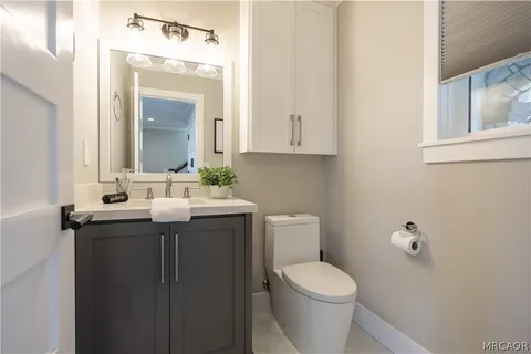 a bathroom with a granite countertop toilet sink and mirror
