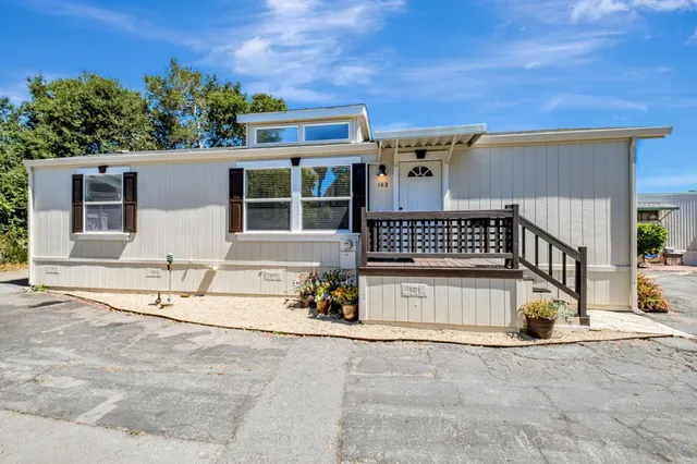 front view of a house with a large window and potted plants