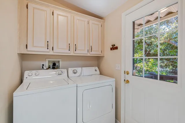 a view of washer and dryer with bathroom in the background