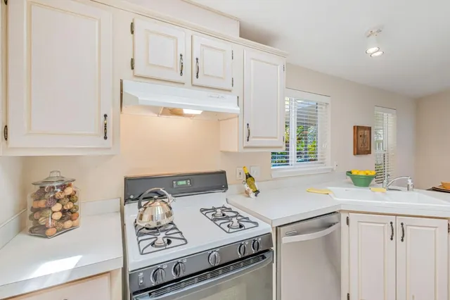 a kitchen with stainless steel appliances granite countertop a sink stove and cabinets