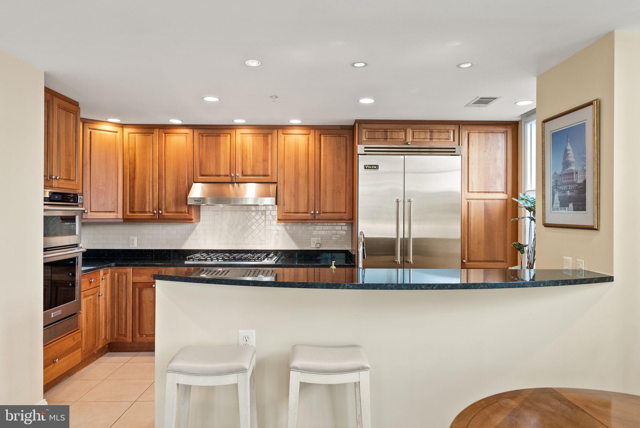 2501 Wisconsin Avenue Northwest, Unit 302 Washington, DC 20007 - Photo 11 of 33 a view of a kitchen with stainless steel appliances granite countertop a stove and a refrigerator