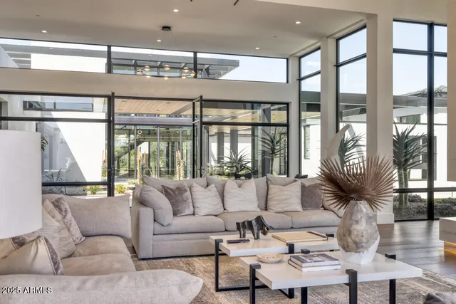 a large living room with stainless steel appliances granite countertop furniture and a large window