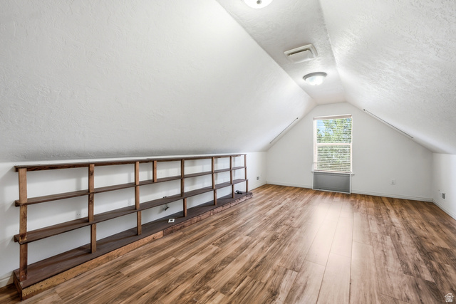 5196 Rodeo Circle Oakley, UT 84055 - Photo 29 of 57 Attic space featuring wood-finish flooring, a built-in shelving unit, and a window with blinds
