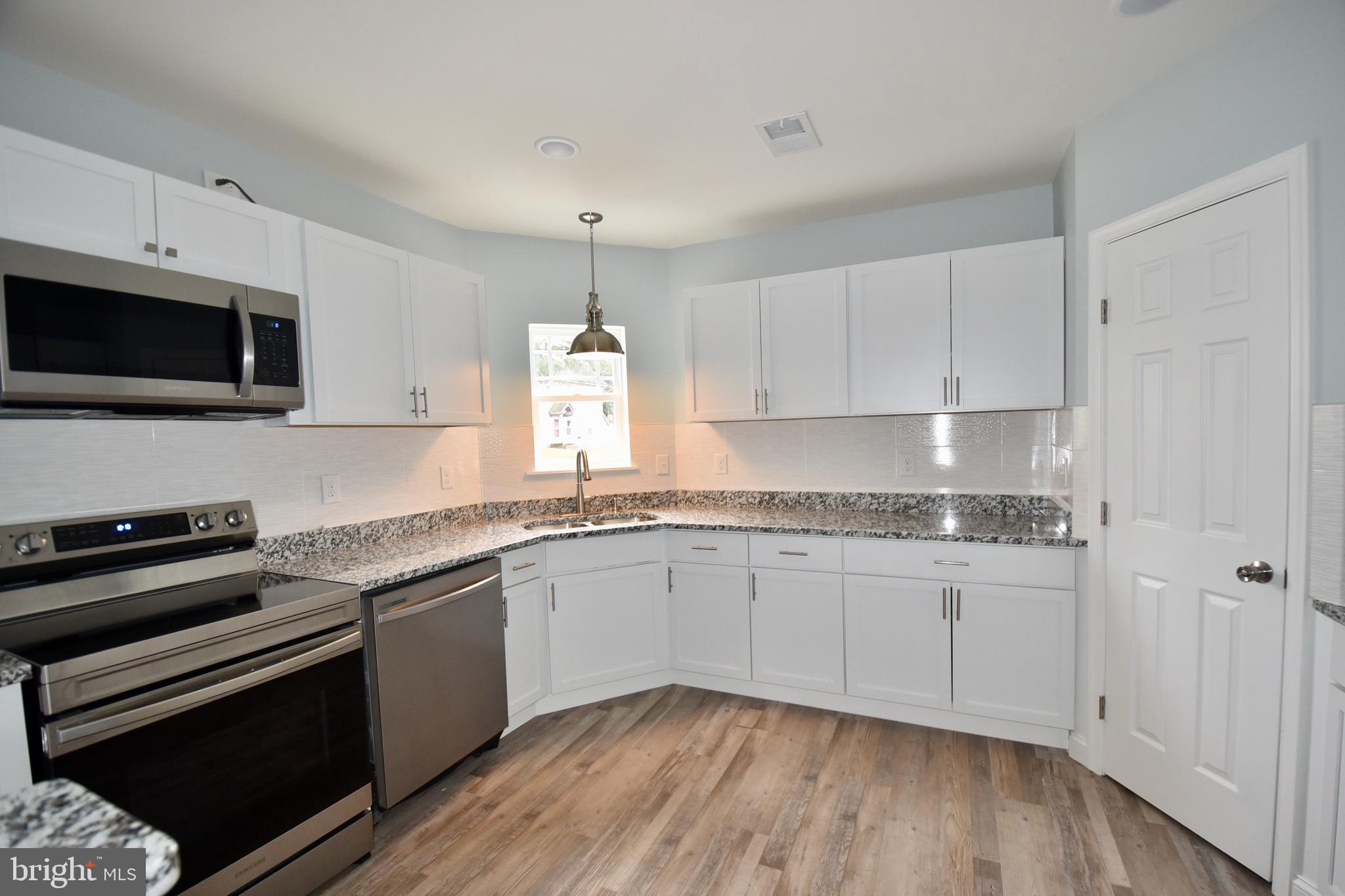 611 Main Street Sharptown, MD 21861 - Photo 19 of 37 a kitchen with granite countertop a sink and a stove top oven