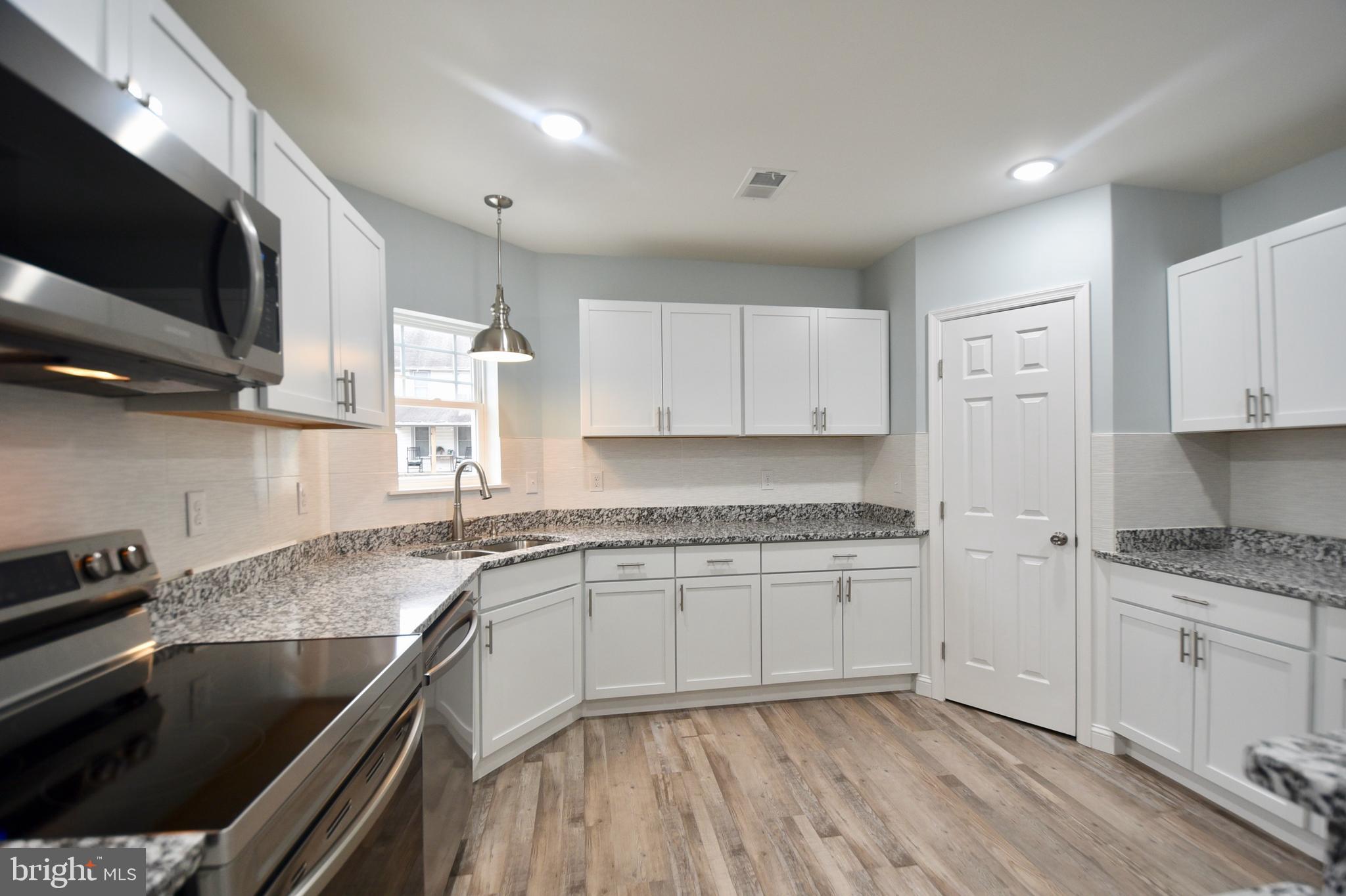 611 Main Street Sharptown, MD 21861 - Photo 5 of 37 a kitchen with a sink stove and cabinets