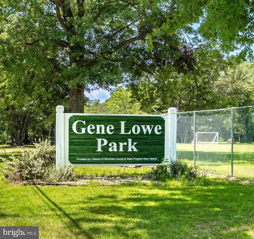a sign of golf club on a wall under a tree