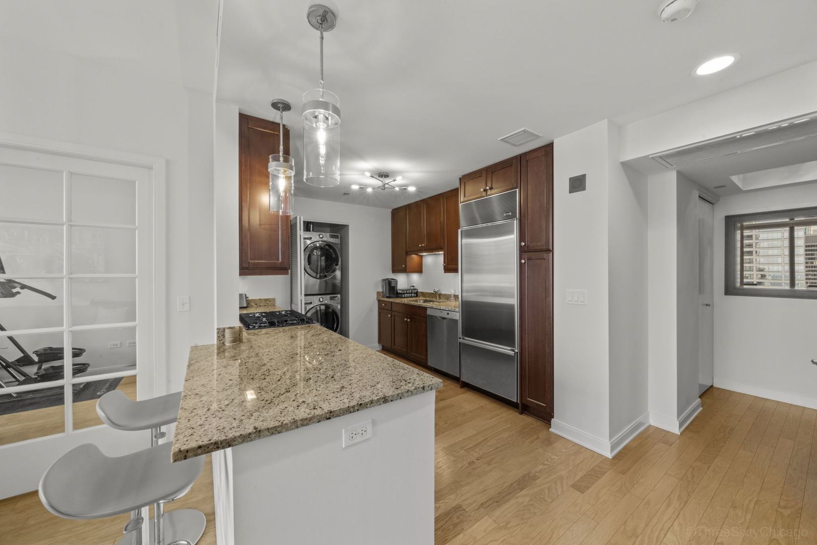 60 East Monroe Street, Unit 2606 Chicago, IL 60603 - Photo 13 of 34 a kitchen with granite countertop kitchen island stainless steel appliances a sink stove and refrigerator