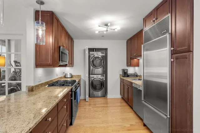 a kitchen with stainless steel appliances granite countertop a refrigerator a stove and a sink