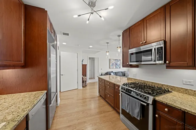 a kitchen with stainless steel appliances granite countertop a stove oven and a refrigerator