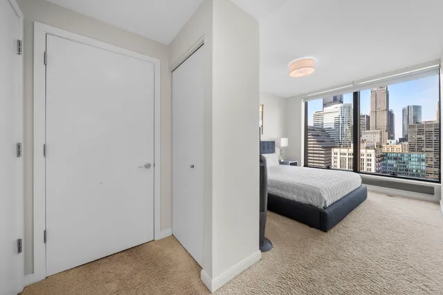 a bedroom with a bed and a large window