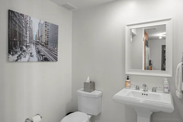 a bathroom with a sink mirror and toilet