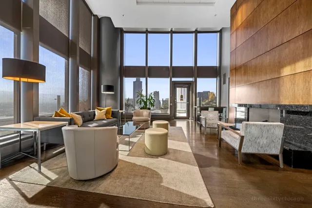 a living room with couches a coffee table and a large window with garden view