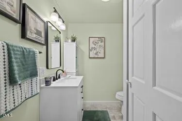 a bathroom with a sink mirror and a toilet