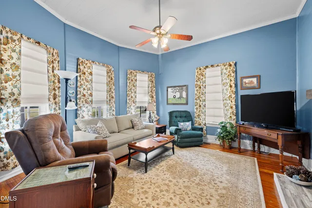 a living room with furniture a flat screen tv and a large window