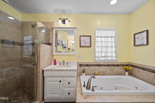 a bathroom with a bathtub sink and mirror