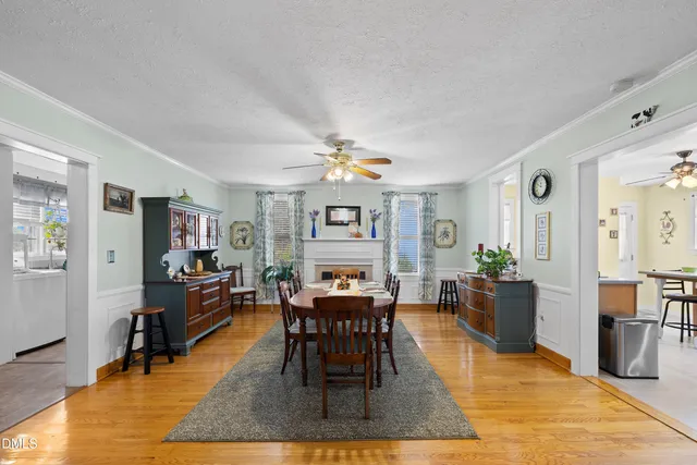 a dining room with wooden floor and stainless steel appliances