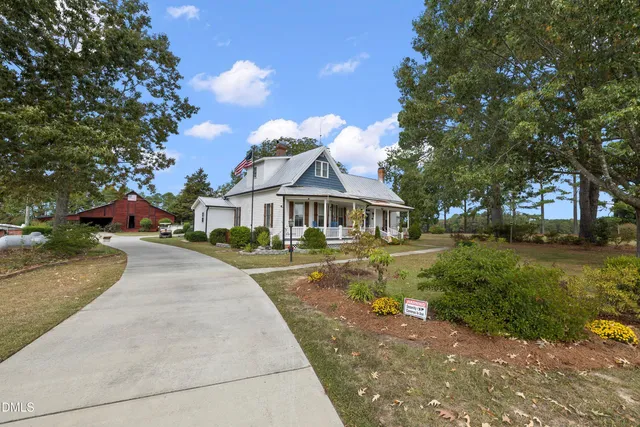 a front view of a house with a yard and trees