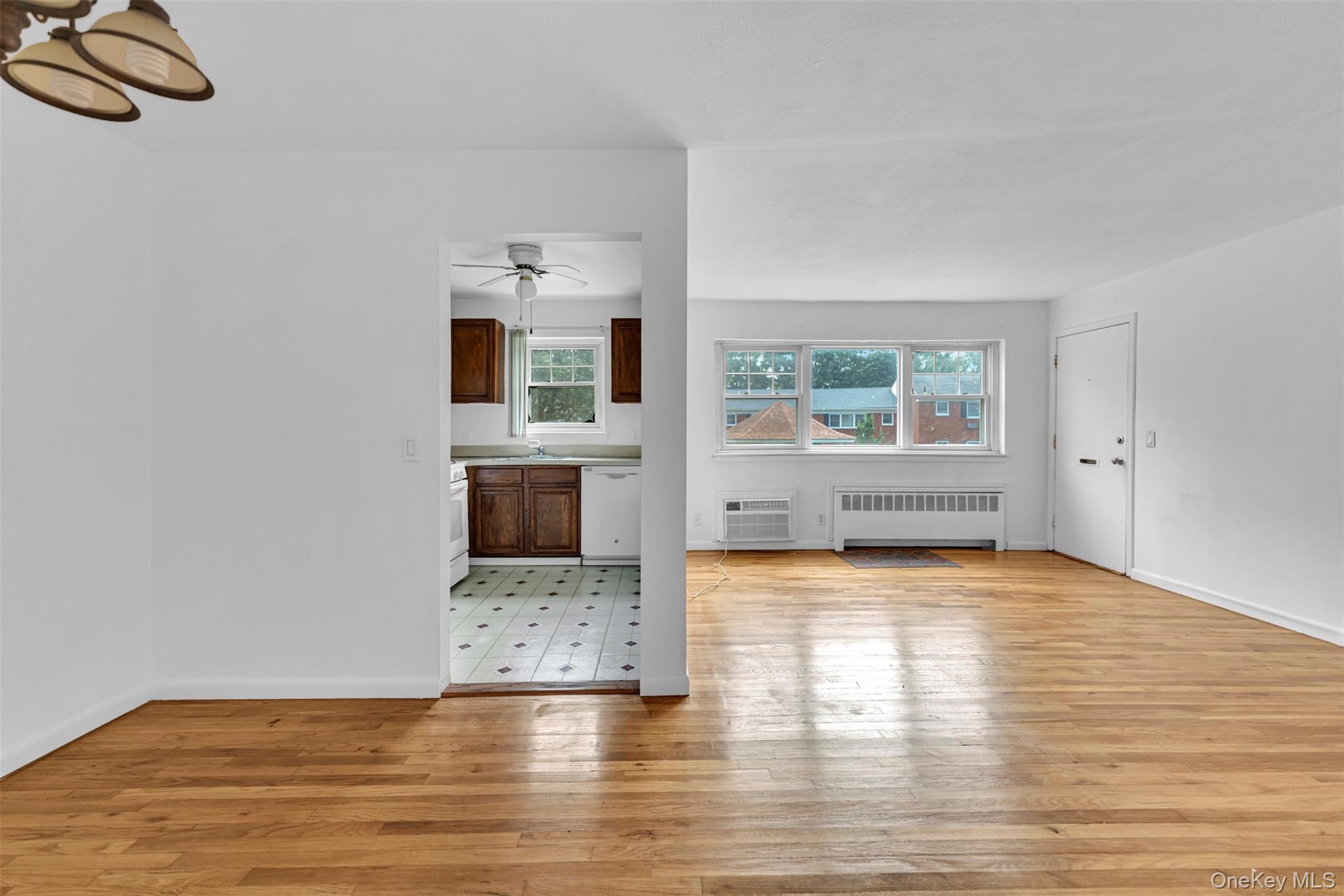 a view of empty room with wooden floor and window
