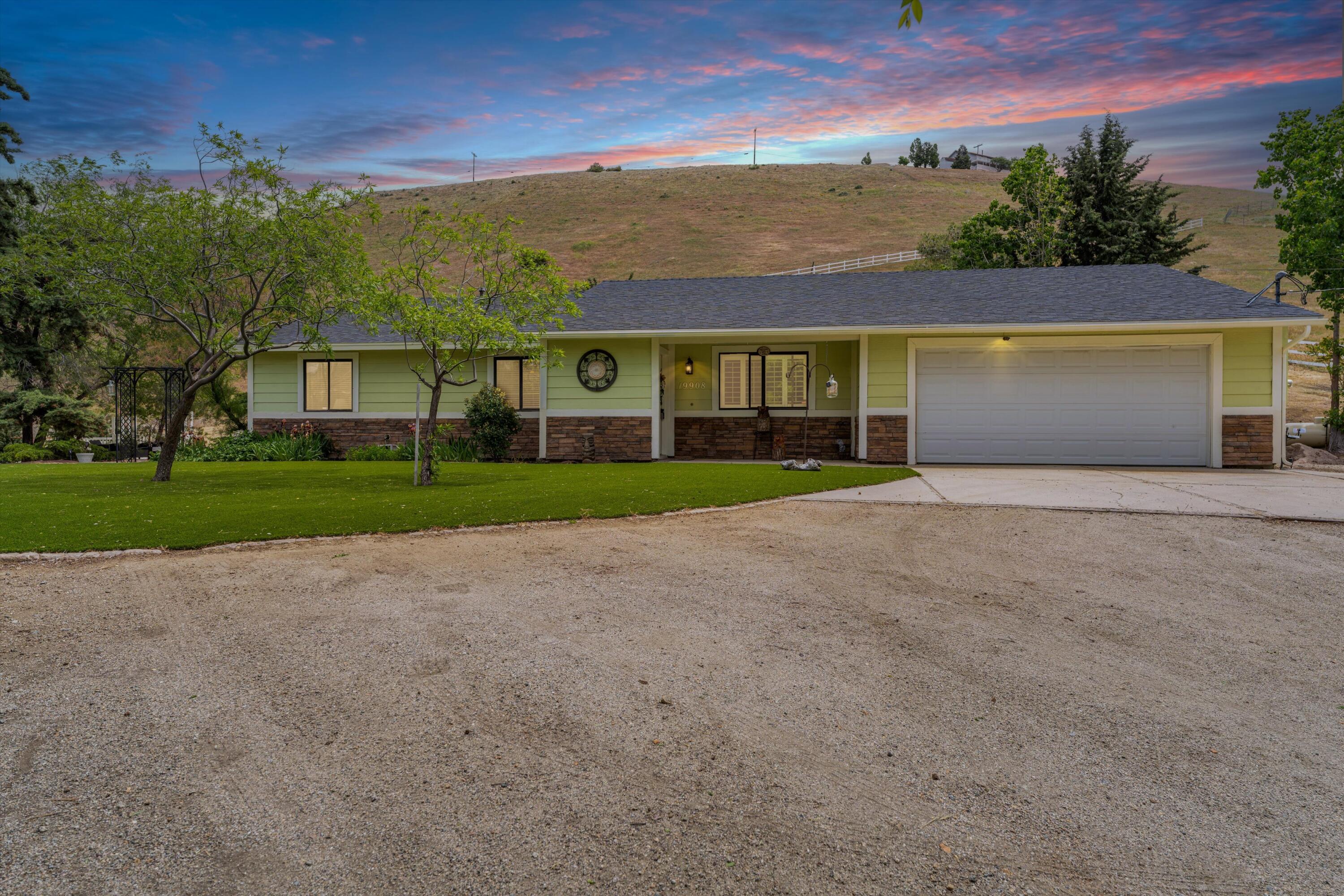 front view of a house with a yard and a garage