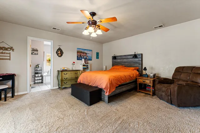 a bedroom with a bed and ceiling fan