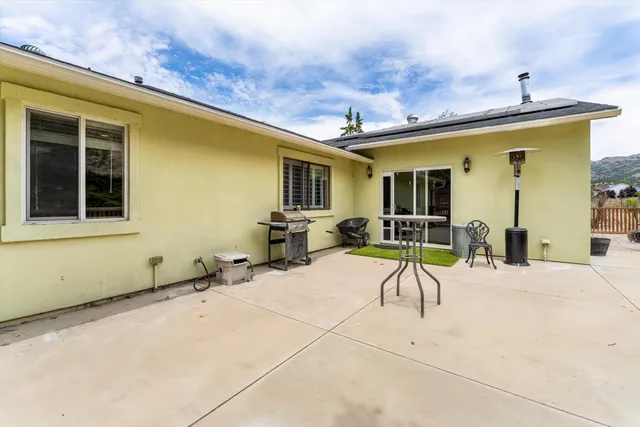 a view of a house with a patio and a yard