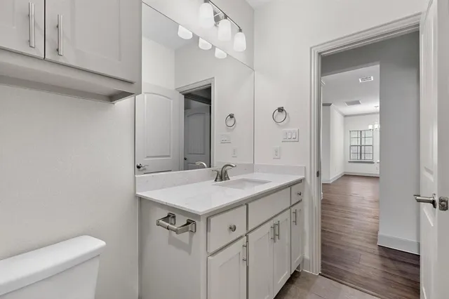 a bathroom with a sink a toilet a mirror and shower