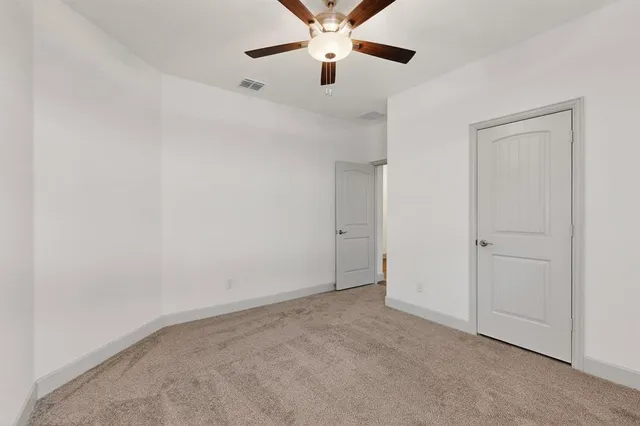an empty room with chandelier fan