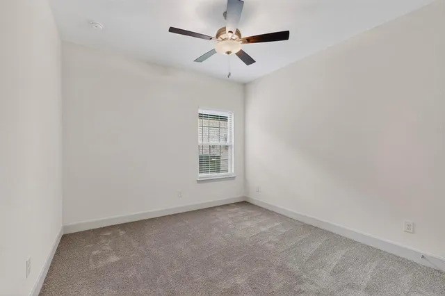 an empty room with chandelier fan