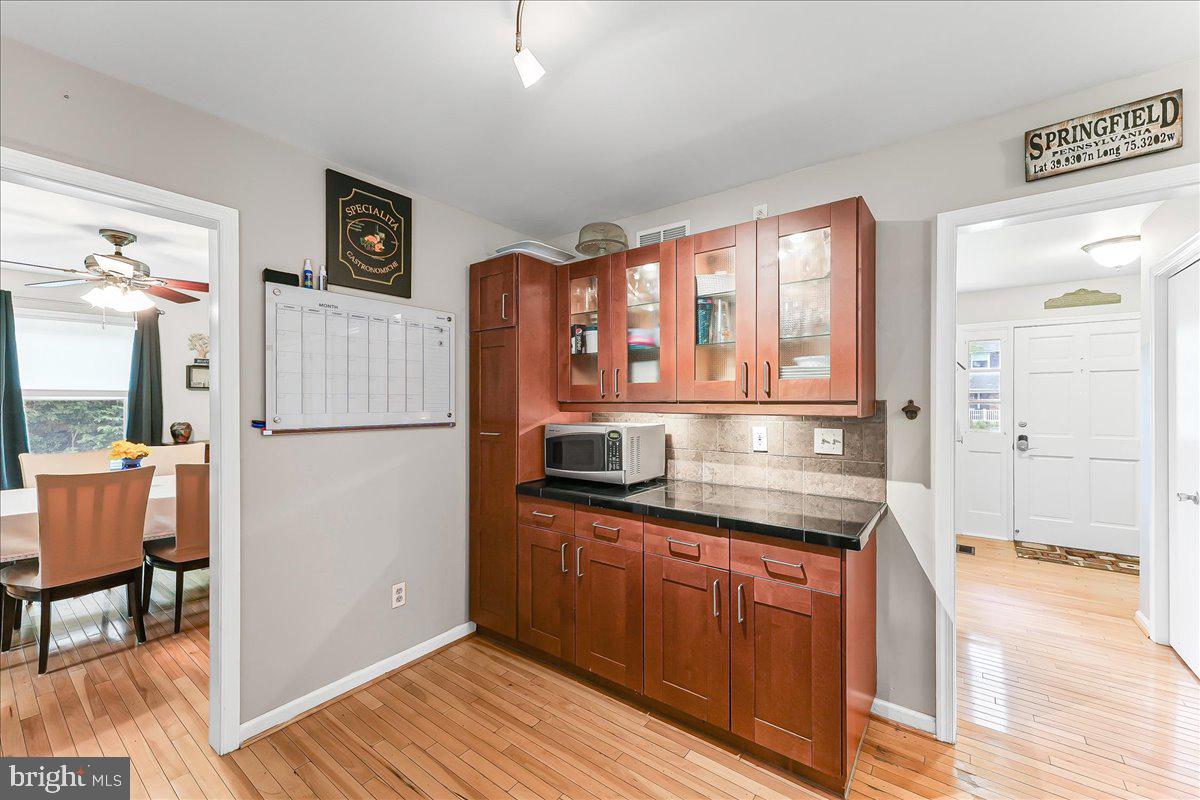 208 Rambling Way Springfield, PA 19064 - Photo 11 of 39 a kitchen with stainless steel appliances granite countertop a refrigerator and a wooden cabinets