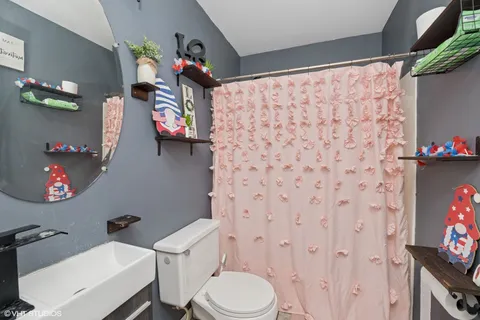 a bathroom with a sink mirror vanity and toilet
