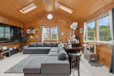 a living room with furniture a large window and a dining table