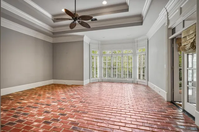 a view of an empty room and window and a ceiling fan
