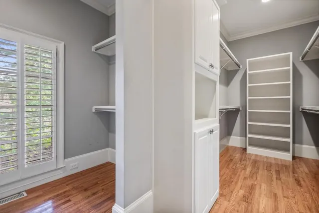 a view of walk in closet with empty racks