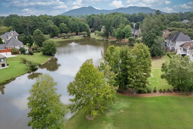 an aerial view of residential houses with outdoor space and lake view