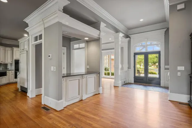 a view of a hallway with wooden floor and a living room