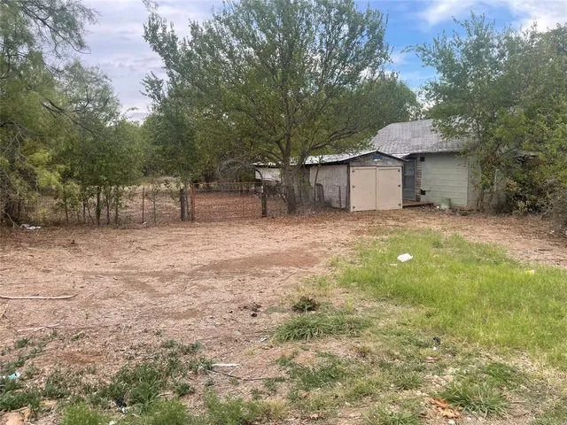 a backyard of a house with table and chairs