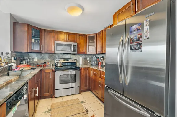 a kitchen with a dining table chairs and refrigerator