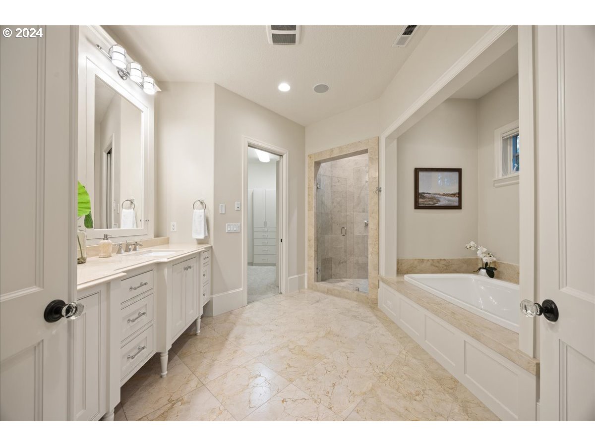 3528 Southwest 64th Place Portland, OR 97221 - Photo 24 of 48 a bathroom with a tub sink double vanity granite tub shower and mirror