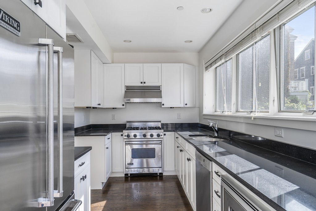 423 Hope Street, Unit 1A Bristol, RI 02809 - Photo 11 of 26 a kitchen with granite countertop a sink stainless steel appliances and cabinets