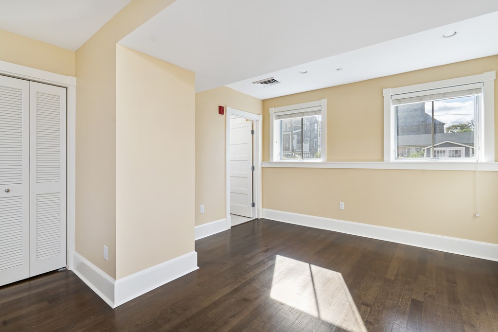 423 Hope Street, Unit 1A Bristol, RI 02809 - Photo 12 of 26 an empty room with wooden floor and windows
