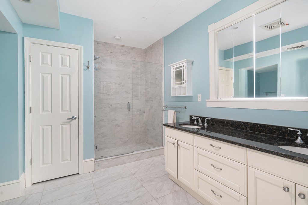 423 Hope Street, Unit 1A Bristol, RI 02809 - Photo 19 of 26 a bathroom with a granite countertop sink a mirror and a shower