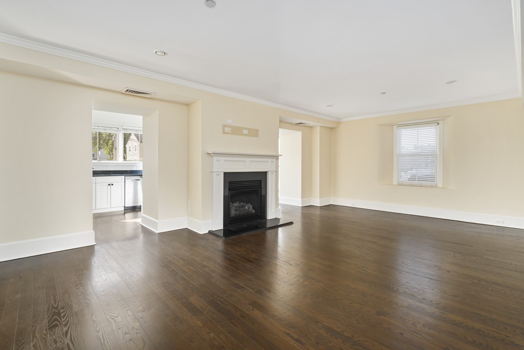 423 Hope Street, Unit 1A Bristol, RI 02809 - Photo 5 of 26 an empty room with wooden floor fireplace and windows