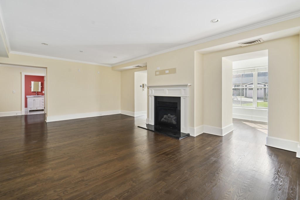 423 Hope Street, Unit 1A Bristol, RI 02809 - Photo 6 of 26 an empty room with wooden floor fireplace and windows