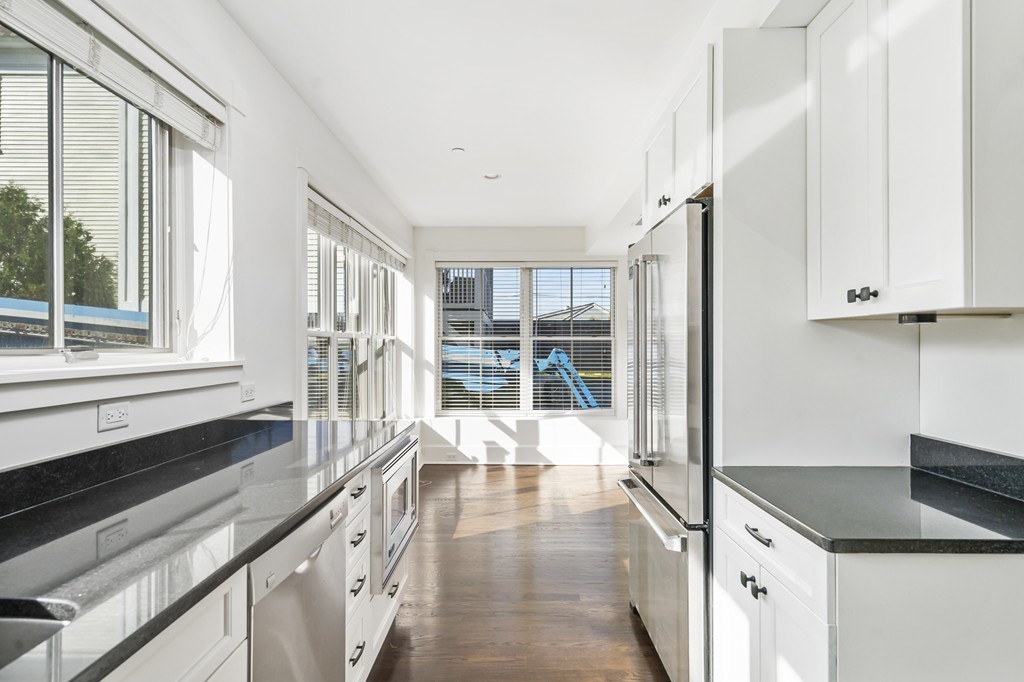 423 Hope Street, Unit 1A Bristol, RI 02809 - Photo 9 of 26 a large white kitchen with granite countertop a sink and a stove top oven