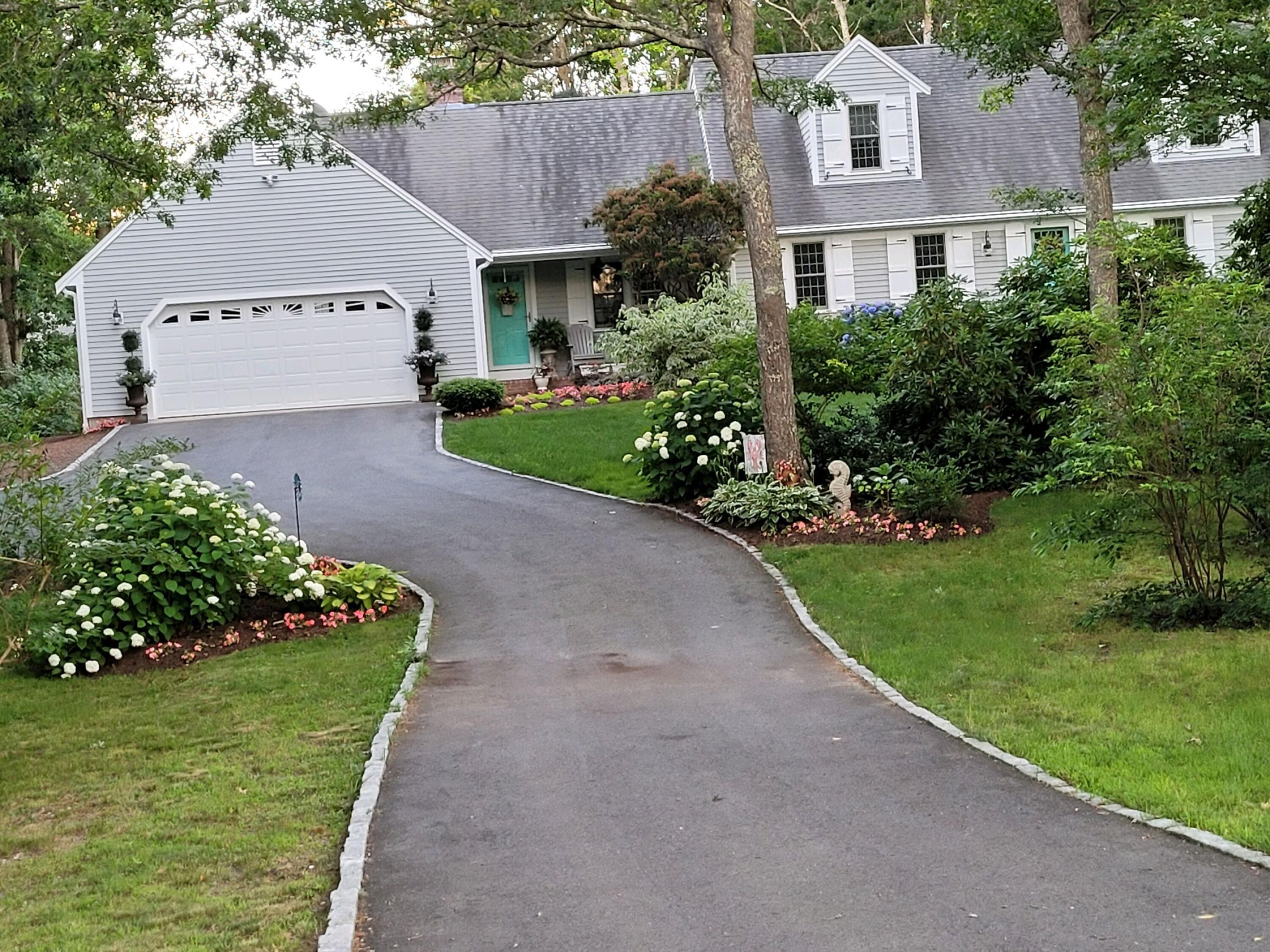 282 Elliott Road Centerville, MA 02632 - Photo 14 of 51 a front view of a house with a garden and trees