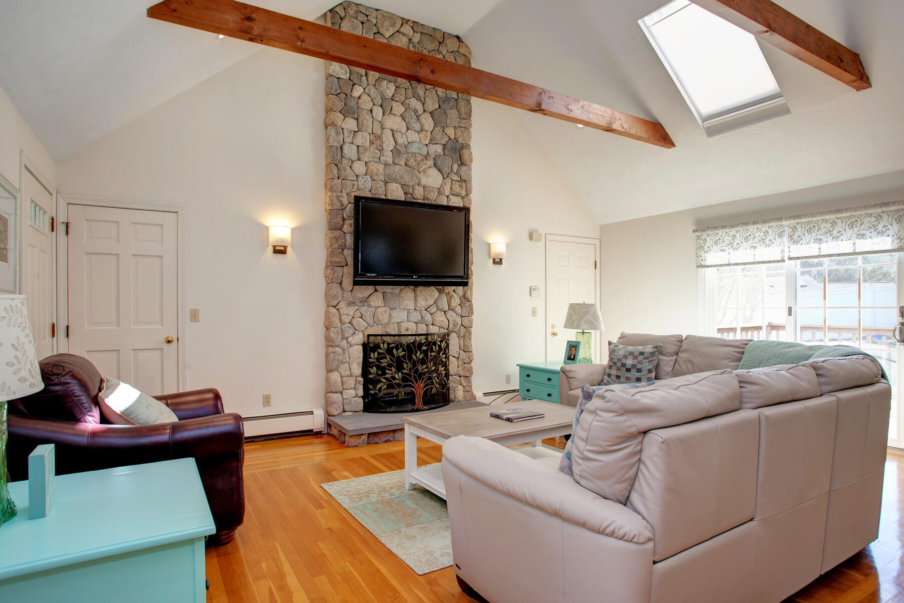 282 Elliott Road Centerville, MA 02632 - Photo 33 of 51 a living room with furniture a fireplace and a flat screen tv