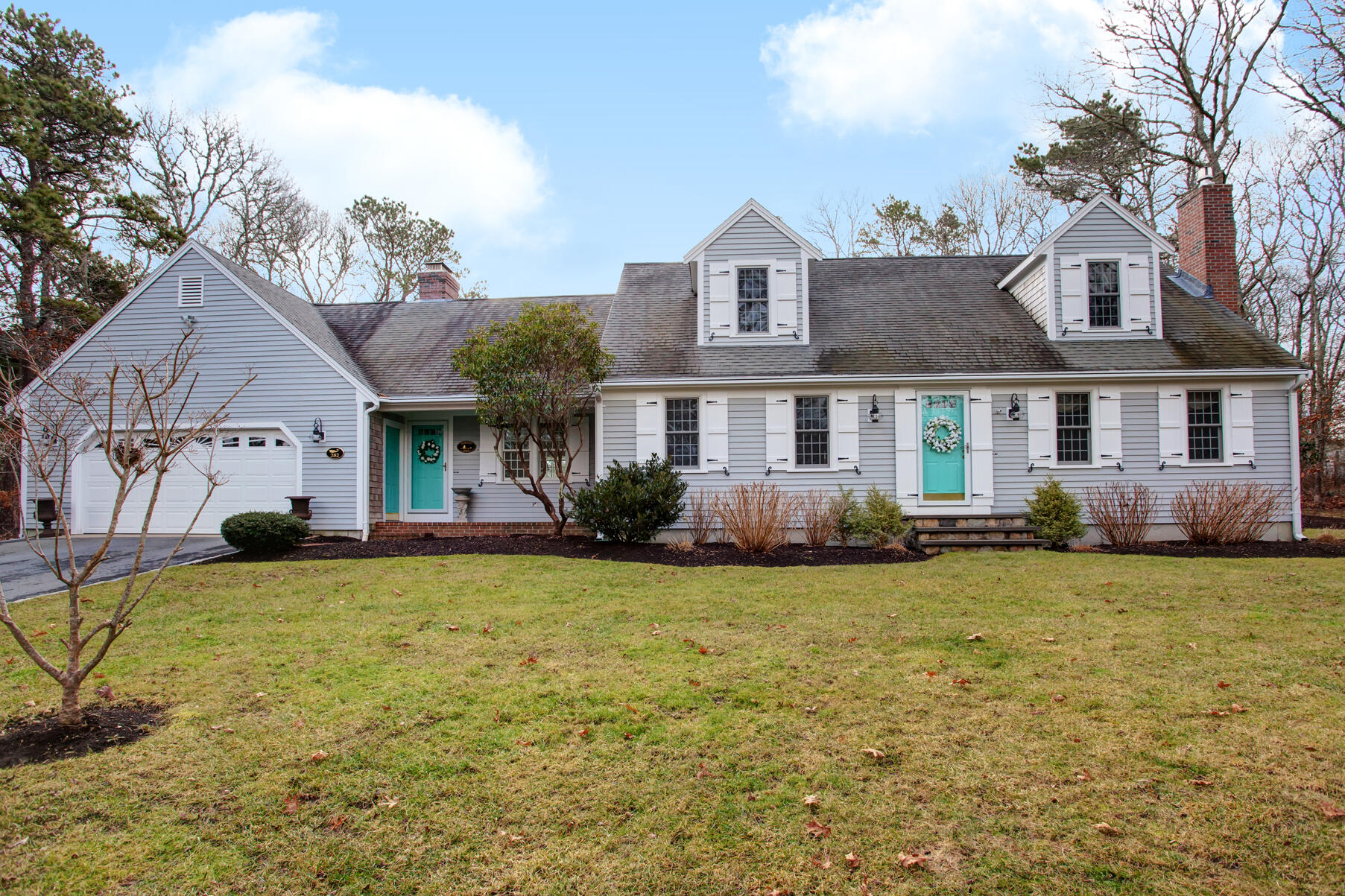 282 Elliott Road Centerville, MA 02632 - Photo 46 of 51 a front view of a house with a garden and trees