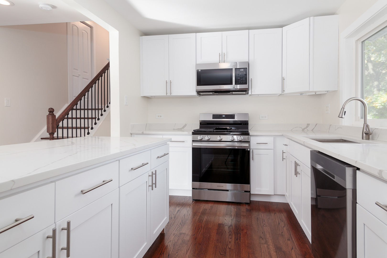 601 Pine Street Deerfield, IL 60015 - Photo 5 of 23 a kitchen with stainless steel appliances white cabinets a sink a stove a microwave and wooden floors
