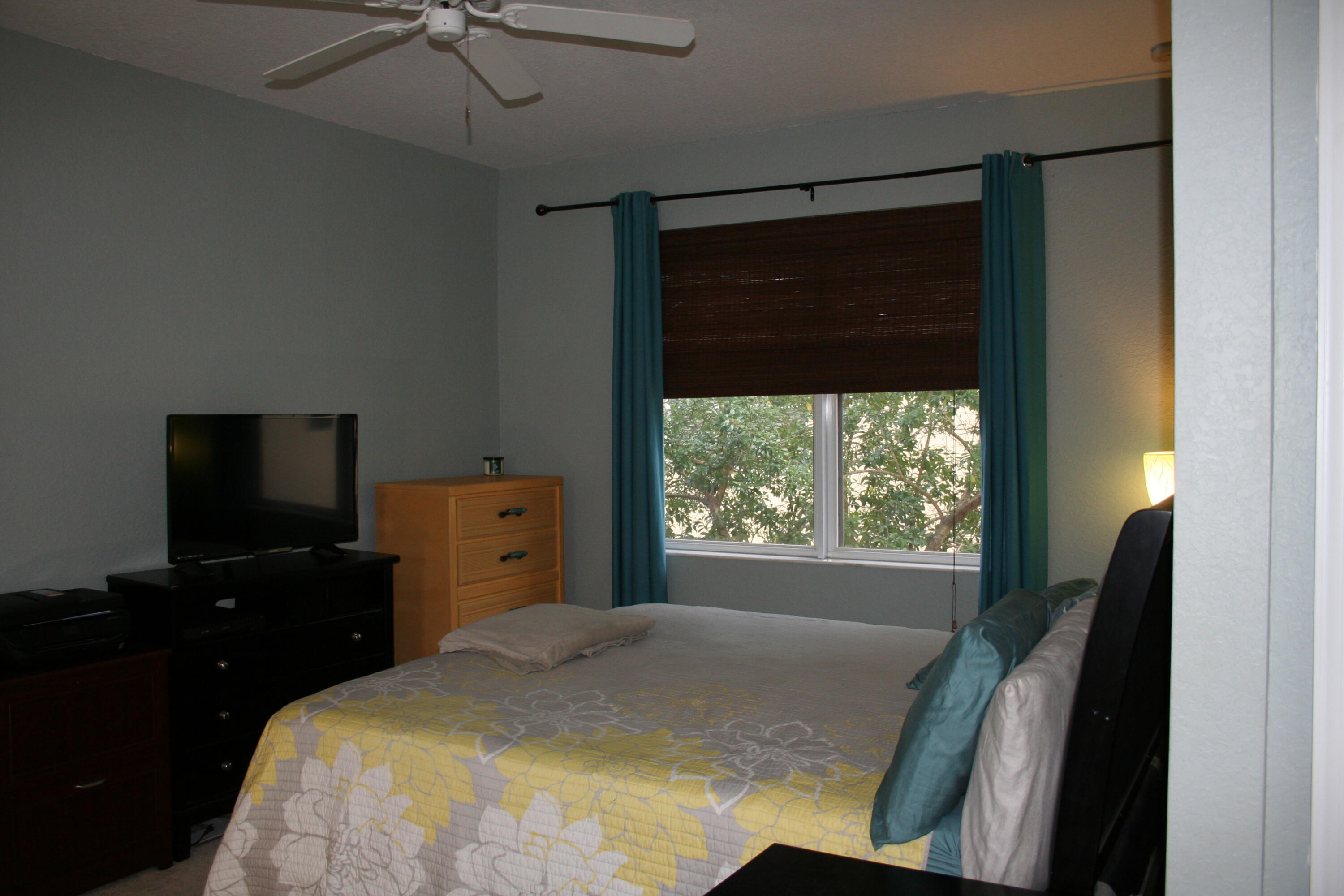9469 Southwest Purple Martin Way Stuart, FL 34997 - Photo 11 of 23 a bedroom with a bed and a flat tv screen on the dresser