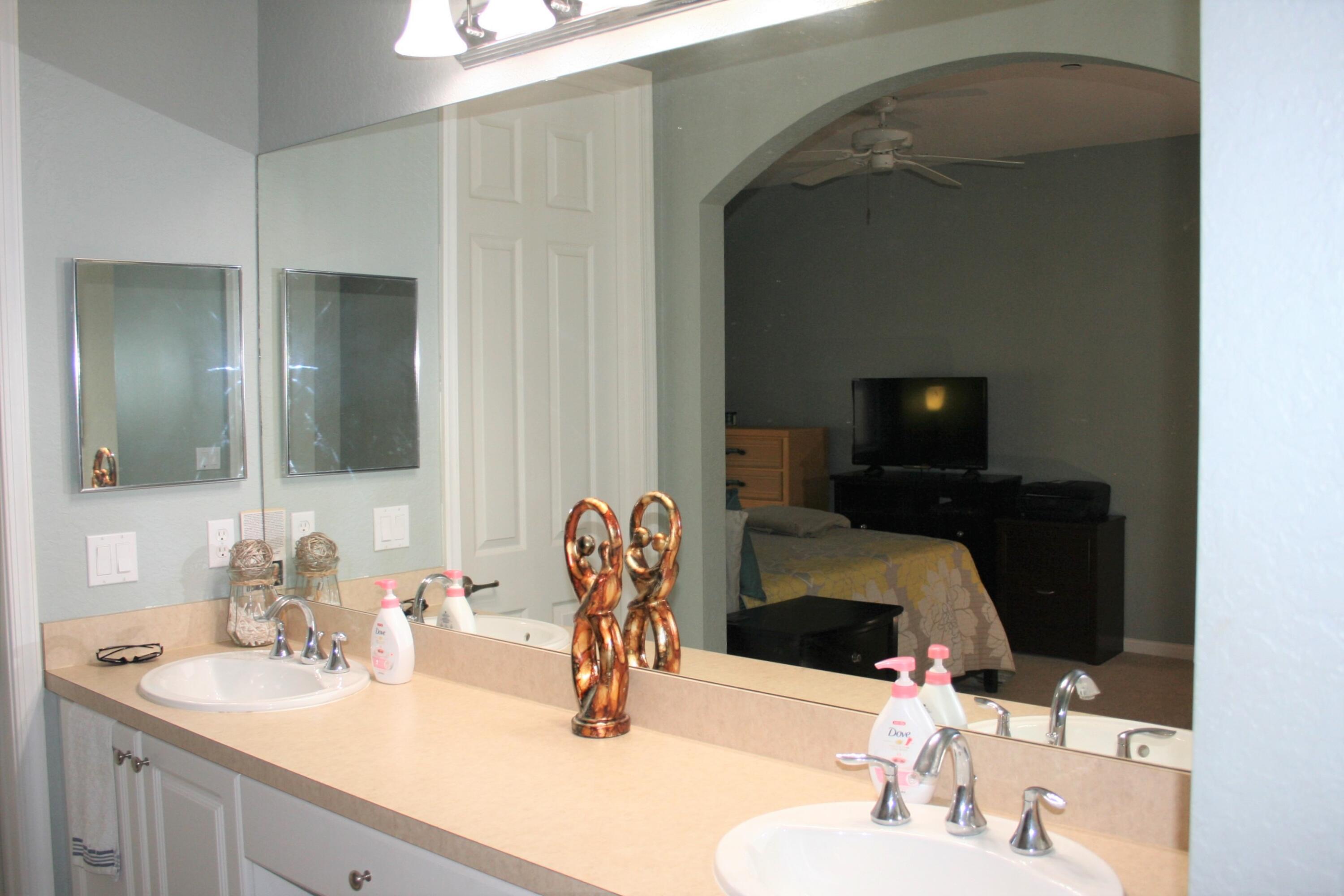 9469 Southwest Purple Martin Way Stuart, FL 34997 - Photo 12 of 23 a bathroom with a sink and a mirror